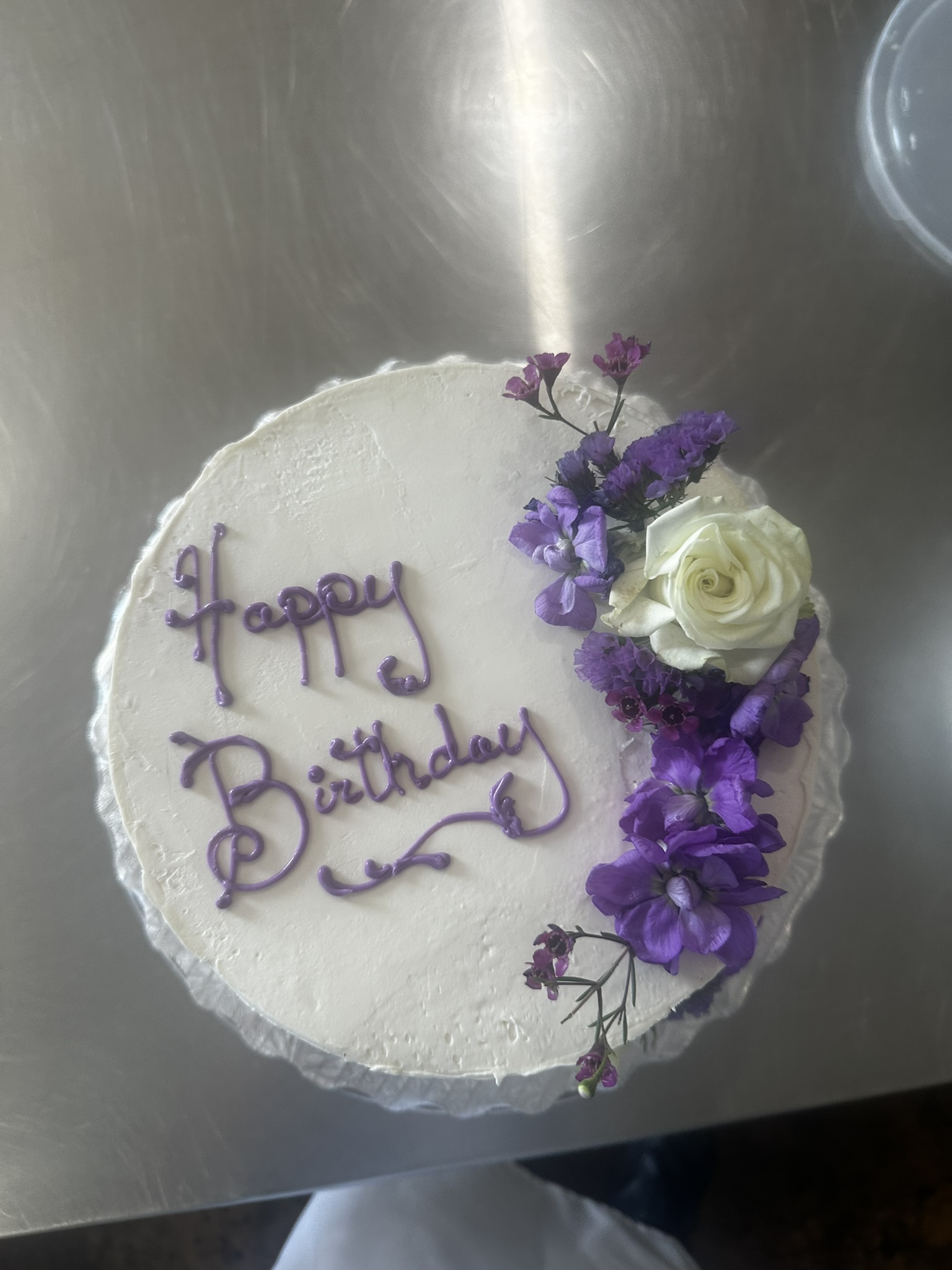 Buttercream birthday cake with script writing and flowers