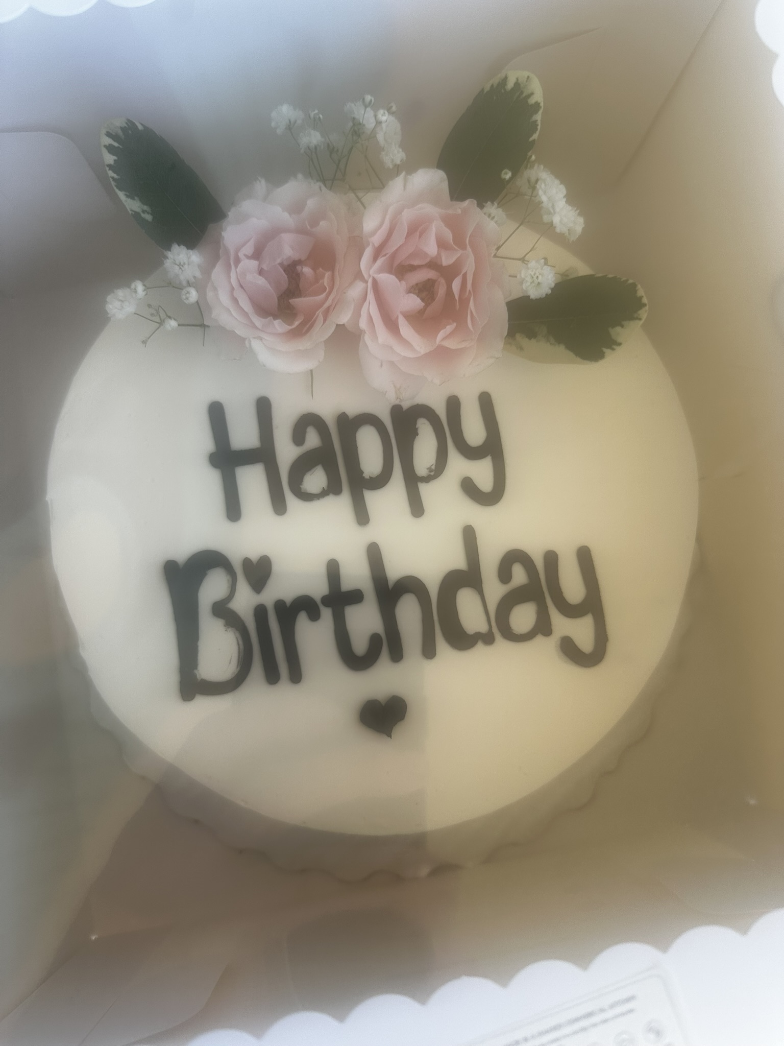 Buttercream birthday cake with pink piping and lilies