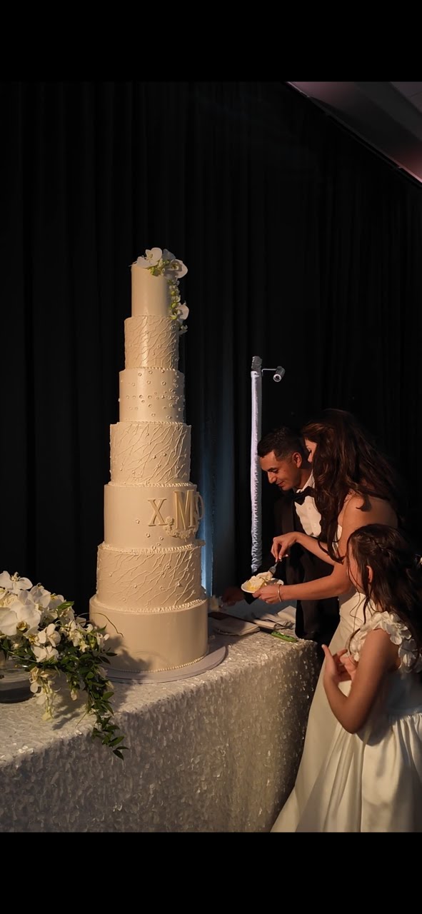 Elegant seven-tier wedding cake with textured European buttercream and floral accents by Peak Cake Co in Colorado Springs
